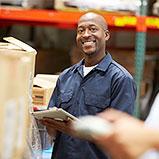 warehouse worker smiling with tablet in hand