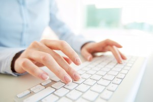 woman's hands typing on keyboard