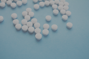 white pill tablets on pale blue surface