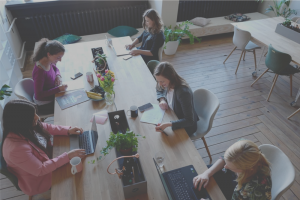 5 ladies working at a table on their laptops