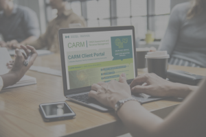 Person typing on laptop with CARM website on screen